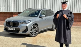 Auto Express special contributor Steve Sutcliffe dressed in a graduation cap and gown, standing next to our long-term BMW X1